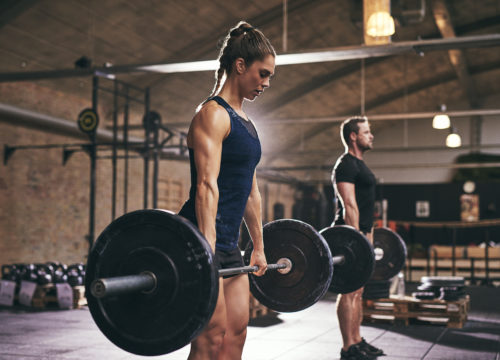 Woman and man lifting weights