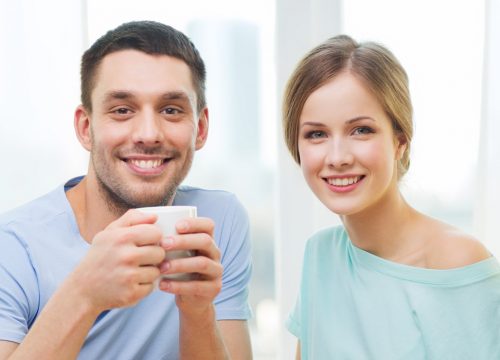 Happy couple having coffee at home