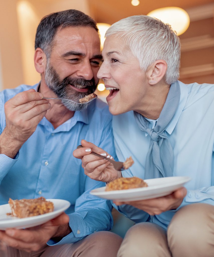Older husband feeding his wife during dinner