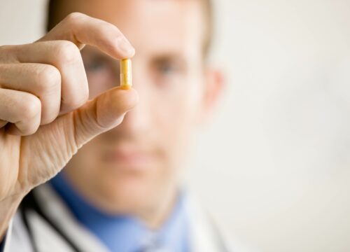 Photo of a doctor holding up a pill