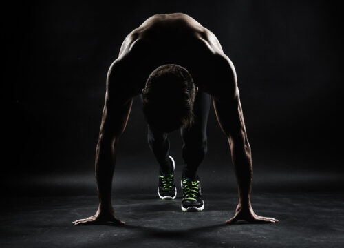 Photo of a man in a set stance, getting ready to sprint